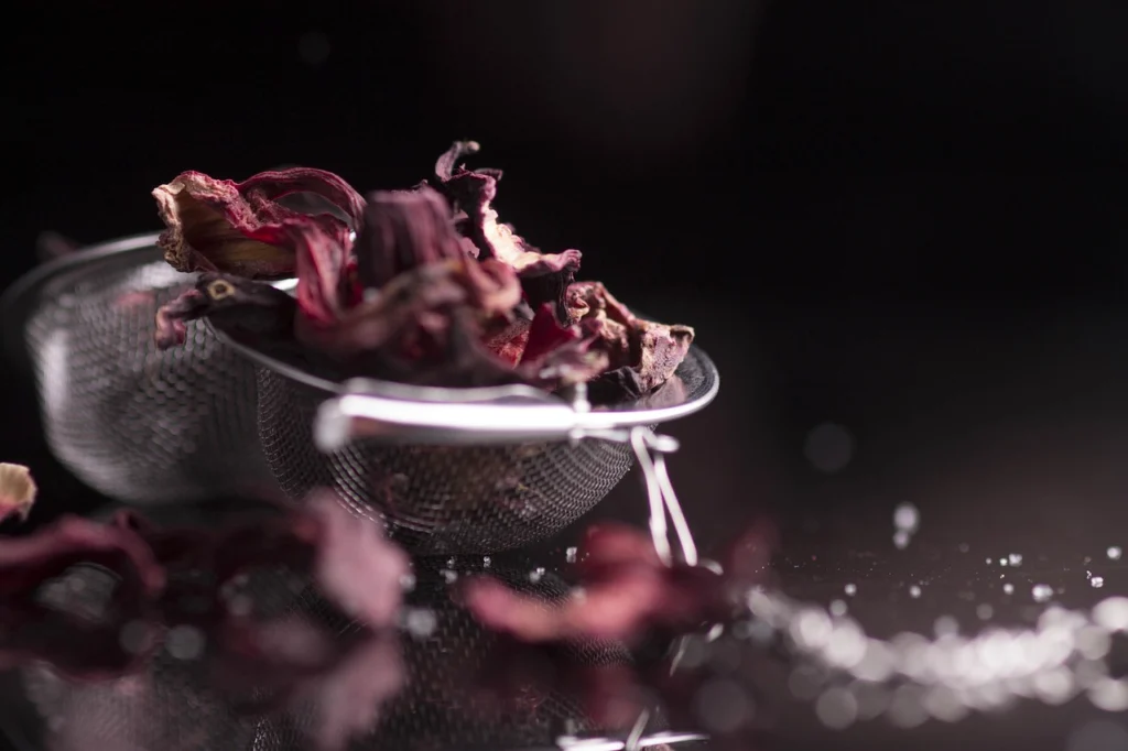 Vaso de agua de flor de Jamaica roja con flores secas